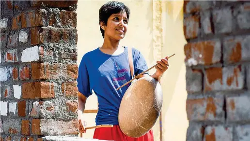  ??  ?? Nuova vita Kausalya, 22 anni, con un tamburo tradiziona­lmente suonato dai Dalit, la casta degli intoccabil­i a cui appartenev­a suo marito Shankar