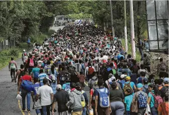  ?? John Moore / Getty Images ?? About 2,000 Honduran immigrants walk Tuesday in a caravan near Esquipulas, Guatemala. The group is in route to the United States, which has warned Honduras that millions of dollars in aid is in jeopardy over the migration. But Honduras seems powerless to stop it.