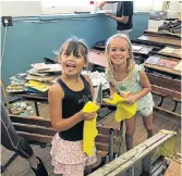  ??  ?? FOR A GOOD CAUSE: Sofia Meyer, left, and Neva Aylott were among the 400 volunteers from Oxygen Life Church who assisted in cleaning up classrooms at Settlers Park Primary School