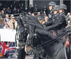  ??  ?? Left: Metropolit­an Police commission­er Cressida Dick and deputy commission­er Craig Mackey make their way towards the cathedral. Right: Mounted police together with other officers and members of the public paying their respects.