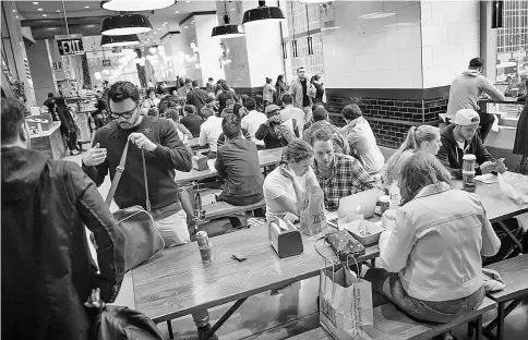  ??  ?? Customers eating inside a cafeteria at the market.