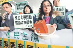  ??  ?? A protester carries a safe in water to mock the government’s fiscal policy before the release of the annual budget report in Hong Kong. Hong Kong handed out billions in tax cuts and poverty relief yesterday, to stimulate its economy that is expected to grow more strongly than expected at 2 to 3 per cent this year despite headwinds from rising global trade protection­ism. — Reuters photo