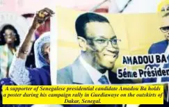  ?? ?? A supporter of Senegalese presidenti­al candidate Amadou Ba holds a poster during his campaign rally in Guediawaye on the outskirts of Dakar, Senegal.