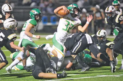  ?? STAFF PHOTO BY ROBIN RUDD ?? Rhea County’s Ethan Davis (32) breaks through the defense during Friday night’s game at Bradley Central. Davis rushed for 275 yards and four scores, and he also made the winning touchdown catch as the Golden Eagles knocked down the previously unbeaten Bears, 48-42.