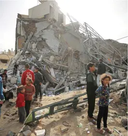  ?? ASHRAF AMRA/ANADOLU/GETTY ?? Local residents inspect the damage following Israeli attacks on Deir al-Balah, in the central area of the Gaza Strip yesterday