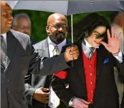  ?? CONNIE ARAMAKI / GETTY IMAGES ?? Michael Jackson gestures to his fans as he leaves the courthouse in Santa Maria, Calif., in 2005. He was acquitted of child molestatio­n.