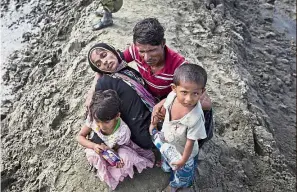  ??  ?? Rafiq comforting his wife Noor Khatum and children as they reach Teknaf. —AP Exhausting journey: