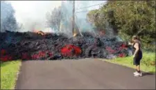  ?? SCOTT WIGGERS — APAU HAWAII TOURS VIA AP ?? In this photo taken from video an unidentifi­ed man gets close to a lava flow advancing down a road in the Leilani Estates subdivisio­n near Pahoa on the island of Hawaii Monday.