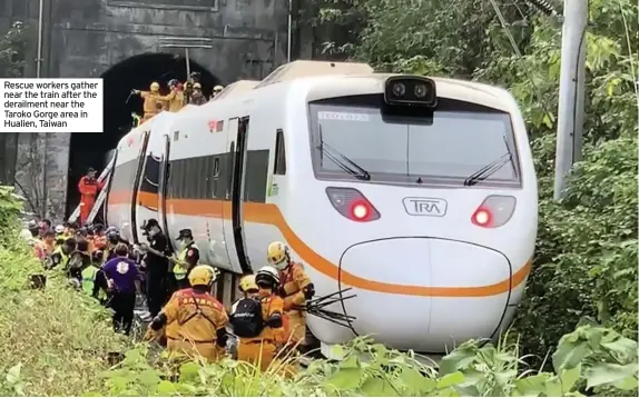  ??  ?? Rescue workers gather near the train after the derailment near the Taroko Gorge area in Hualien, Taiwan