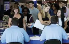  ?? AP PHOTO/LYNNE SLADKY, FILE ?? Job applicants speak with representa­tives from Aldi at a job fair hosted by Job News South Florida, in Sunrise, Fla.