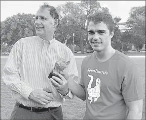  ?? Arkansas Democrat-Gazette/FRANK E. LOCKWOOD ?? U.S. Sen. John Boozman presents the hog-head trophy to Alex Hanson, pitcher for U.S. Sen. Tom Cotton’s winning team.