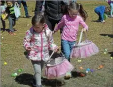  ?? PETE BANNAN — DIGITAL FIRST MEDIA ?? Cousins Madison Roach, 4, and Colette Roach, 5, of West Chester gather some of the 12,000 eggs during the 14th annual First Presbyteri­an Church Easter Egg Hunt at Everhart Park Saturday.