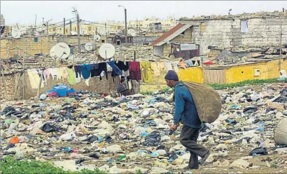  ?? ABDELHAK SENNA / AFP ?? El país del plástico. Un marroquí caminando por una barriada de las afueras de Casablanca, inundada de
basura y plásticos