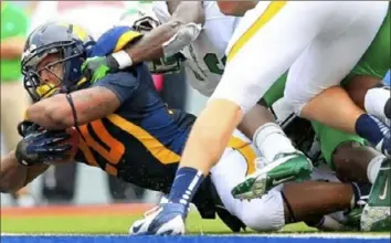  ?? Christophe­r Jackson/Associated Press ?? West Virginia running back Shawne Alston dives in for a touchdown against Marshall on Sept. 1, 2013, in Morgantown, W.Va.