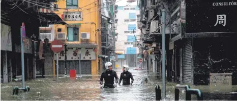  ?? FOTO: AFP ?? Schwierige Rettungsmi­ssion in Macau: Einsatzkrä­fte kämpfen sich am Sonntag nach dem Taifun „Mangkhut“durch die Fluten.