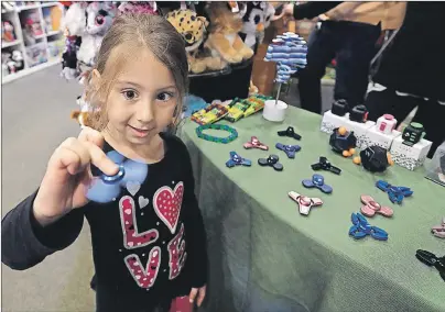  ?? AP PHOTO/CARLOS OSORIO ?? Penelope Daversa, 4, plays with a fidget spinner at the Funky Monkey Toys store, in Oxford, Mich.