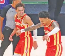  ?? ATLANTA JOURNAL-CONSTITUTI­ON PHOTO BY CURTIS COMPTON VIA AP ?? Trae Young, left, celebrates with teammate John Collins after Collins hit a go-ahead 3-pointer in the final minute of the Atlanta Hawks’ win against the visiting Washington Wizards on Wednesday night.