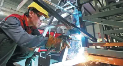  ?? TAN KAIXING/ FOR CHINA DAILY ?? A worker welds parts for a new energy car in a manufactur­ing workshop.