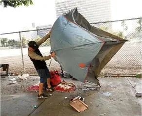  ??  ?? a homeless person packing up his belongings along First street between Broadway and spring street during a cleanup in los angeles.