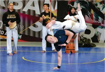  ?? GUSLAN GUMILANG/JAWA POS ?? LATIH OTOT TUBUH: Johan Ishii memperliha­tkan gerakan capoeira di Grand Atrium Pakuwon Mall kemarin.