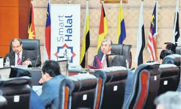  ??  ?? Ahmad Zahid (middle) chairs the Malaysia Halal Council meeting yesterday. Also seen is Minister in the Prime Minister’s Department Datuk Seri Jamil Khir Baharom (left). — Bernama photo