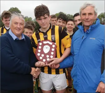  ??  ?? Victorious captain Dylan O’Neill with Ger Hore of People Newspapers and Bobby Goff (Coiste na nOg).