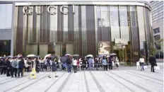  ?? — AFP ?? Customers line up as they wait to go inside a Gucci store at a shopping mall, in Florance, Italy, in this file photo.