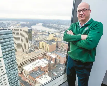  ?? AARON FLAUM/HARTFORD COURANT ?? David W. Griggs, chief executive of the MetroHartf­ord Alliance, shows the view of 242 and 280 Trumbull St. from Bank of America’s 35th floor at City Place I in Hartford. Both buildings — 280 Trumbull is the taller, at far left — have large blocks of space for lease.