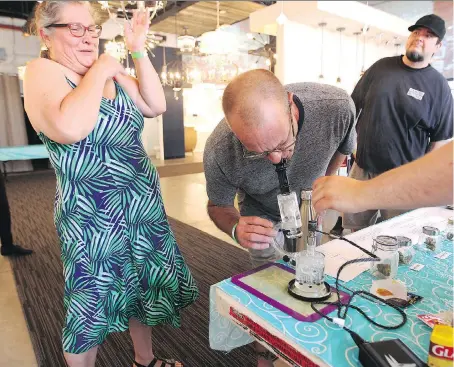  ?? WINDSOR STAR ?? A medicinal cannabis user, left, reacts to a sampling of product during a cannabis pop-up market in Ford City on Sunday morning. The woman was joined by her spouse, centre, at the pop-up market. A dozen vendors took part in the five-hour event.