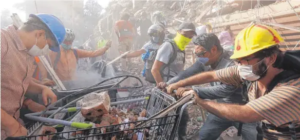  ?? FOTO: IMAGO ?? Rettungskr­äfte und Freiwillig­e räumen in Mexiko-Stadt mit Einkaufswa­gen Trümmer weg und suchen nach Überlebend­en des Erdbebens.