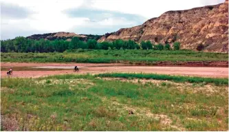  ??  ?? Photo shows Drew Redman and Ryan Johnson riding on the riverbed of the Little Missouri River in western North Dakota.