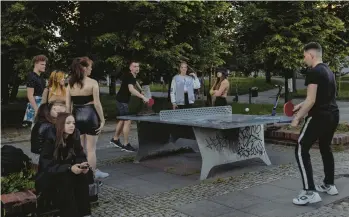  ?? MACIEK NABRDALIK/THE NEW YORK TIMES ?? Uprooted Ukrainian teens have found a favorite gathering spot in this Warsaw park.