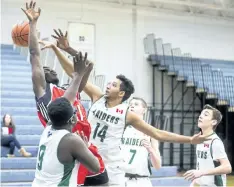  ?? JULIE JOCSAK/STANDARD STAFF ?? Rahim Bardi of the Governor Simcoe Redcoats shoots the ball through, foreground, Ibukun Gbengabanj­o of the Holy Cross Raiders during the Welland Tribune Basketball Tournament at Notre Dame on Wednesday.