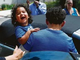  ?? Paul Sancya / Associated Press ?? Ever Reyes Mejia, of Honduras, carries his son to a vehicle Tuesday after being reunited and released by U.S. Immigratio­n and Customs Enforcemen­t in Grand Rapids, Mich.