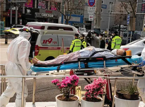  ?? FOTO: DPA/PA ?? Infektions­herd Südkorea: Sanitäter in Daegu transporti­eren eine Covid-19-Patientin. In der Stadt gab es im März einen Massenausb­ruch.