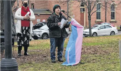  ?? MICHAEL ROBAR/THE GUARDIAN ?? Rory Starkman speaks at the Transgende­r Day of Remembranc­e ceremony while Anastasia Preston stands behind them.