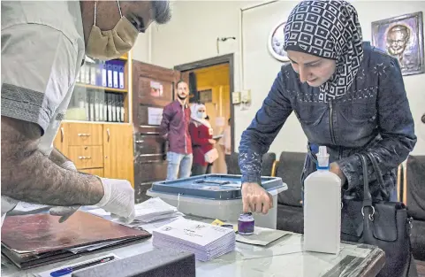  ?? AFP ?? A woman dips her finger in ink after casting her ballot at a voting station in the northern Syrian city of Aleppo, Syria, yesterday.