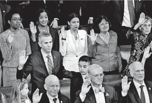  ?? OLIVIER DOULIERY/ABACA PRESS ?? Rep. Alexandria Ocasio-Cortez, D-N.Y., (center) and other members of the House of Representa­tives are sworn in by House Speaker Nancy Pelosi at the U.S. Capitol on Jan. 3.