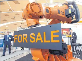  ?? FOTO: DPA ?? Ein Roboter vom Augsburger Hersteller Kuka wird zum Verkauf angeboten. Chinesisch­e Investoren kaufen am liebsten Unternehme­n aus Baden-Württember­g auf – gefolgt von Nordrhein-Westfalen und Bayern.