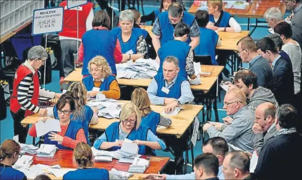  ?? JEFF J MITCHELL / GETTY ?? Un grupo de norirlande­ses verifican manualment­e los votos de las elecciones del jueves, en Ballymena
