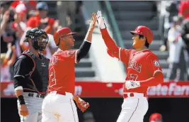  ?? Jae C. Hong ?? The Associated Press Los Angeles Angels designated hitter Shohei Ohtani, right, of Japan celebrates his two-run home run with teammate Andrelton Simmons as Cleveland Indians catcher Yan Gomes watches on Wednesday in Anaheim, Calif.