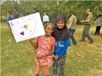  ?? NANCY DEGENNARO/USA TODAY NETWORK-TENNESSEE ?? Mayar Omer, left, and Maryam Yadudu display a sign with the message “We Love Your Neighbors” they made Sunday at the Love Your Neighbor Picnic at in Murfreesbo­ro, Tenn.