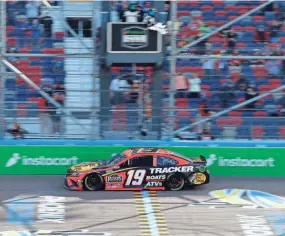  ?? RALPH FRESO/AP ?? Martin Truex Jr. takes the checkered flag to win a NASCAR Cup Series auto race at Phoenix Raceway on March 14.