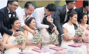  ?? WICHAN CHAROENKIA­TPAKUL ?? Grooms hug their brides after registerin­g their marriages during the 2018 Singha Park Chiang Rai Internatio­nal Balloon Fiesta which runs until this Sunday. A marriage registrati­on ceremony was also held to celebrate Valentine’s Day during the event.