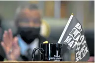  ??  ?? State Rep. Tony Exum sits at his desk in the House chambers with a Black Lives Matter flag in the foreground.