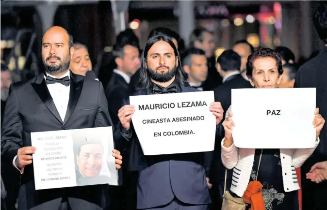  ??  ?? Ciro Guerra, Franco Lolli y Leticia Gómez, la madre de este último, protestaro­n en el festival de Cannes por el asesinato de líderes sociales en Colombia.