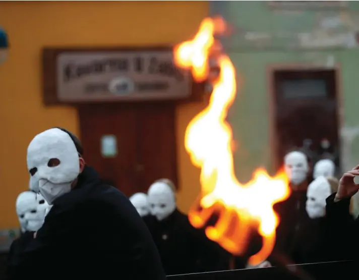  ??  ?? Participan­ts dressed in black, wearing masks, beating drums and pushing small carts making a synchroniz­ed and loud sound take part in an Easter procession marching through the streets of Ceske Budejovice, Czech Republic, Thursday, April 1, 2021. Photo: AP