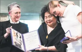  ?? Berit Roald / Associated Press ?? Leader of the Nobel committee Berit Reiss-Andersen, left, presents the award to Hiroshima survivor Setsuko Thurlow and Beatrice Fihn, leader of Internatio­nal Campaign to Abolish Nuclear Weapons, winner of the Nobel Peace Prize 2017, in Oslo on Sunday.