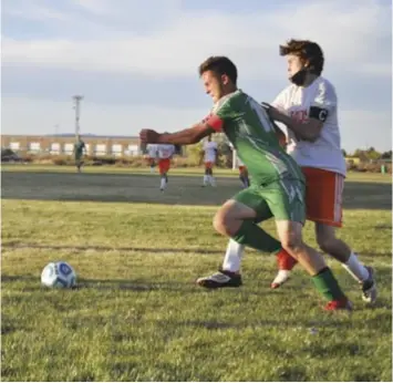  ?? Photo by Ger Demarest. ?? Moriarty's Christophe­r Mcgrath tries to fight his way past a Taos defender near the Tigers' goal in the first half of the Pintos' final game, Oct. 21, 2021.