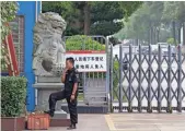  ?? ANDY WONG, AP ?? A security guard keeps watch at an entrance to the Jiangxi Huajian factory.